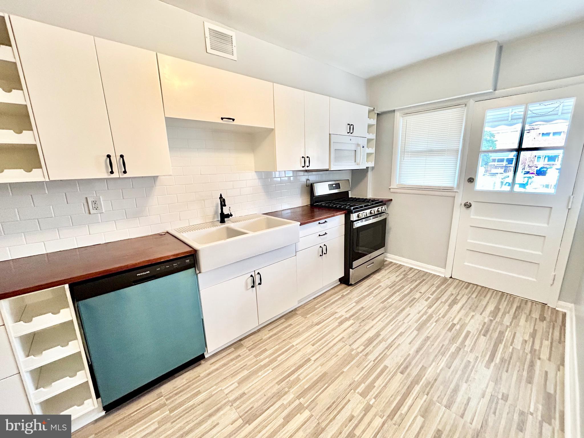 6116 Edlynne Road Baltimore, MD 21239 - Photo 7 of 18 a kitchen with a sink a window and stainless steel appliances