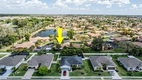 an aerial view of residential houses with outdoor space and lake view