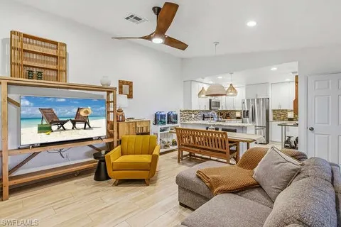 a living room with furniture and a view of kitchen