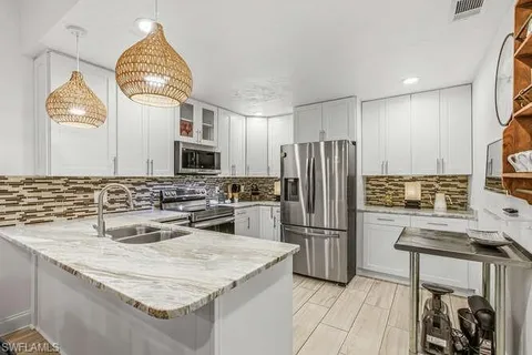 a kitchen with granite countertop a sink stainless steel appliances and cabinets