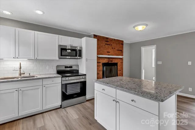 a kitchen with granite countertop a stove and a sink