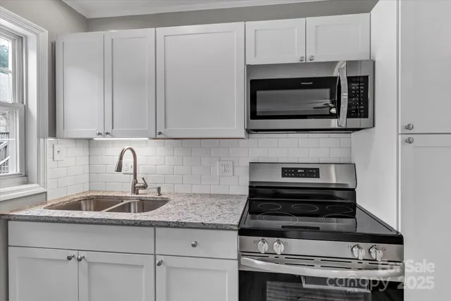 a kitchen with granite countertop a stove top oven a sink dishwasher and a fireplace with wooden floor