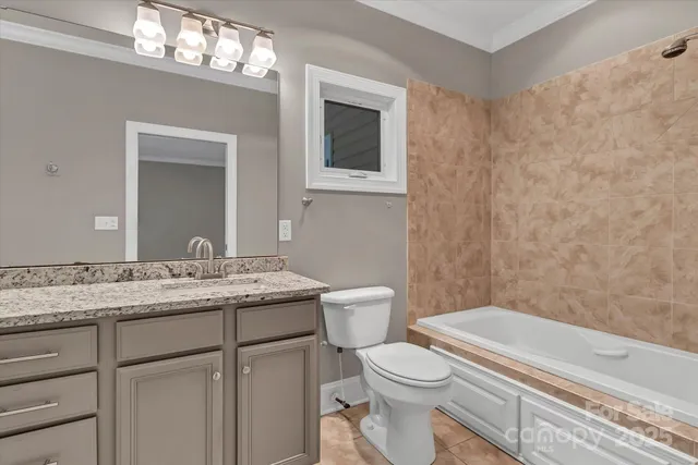 a bathroom with a granite countertop sink a toilet and a mirror