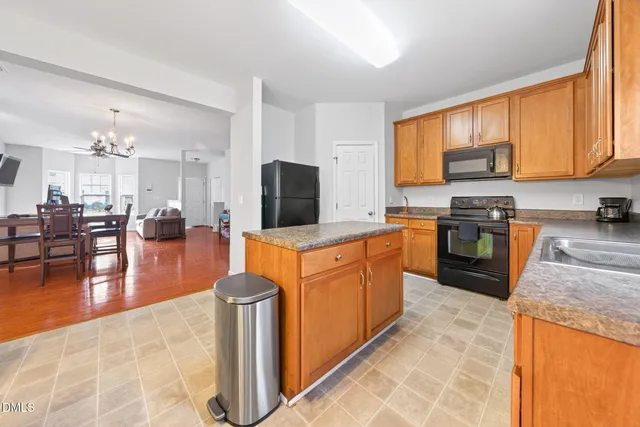 a large kitchen with stainless steel appliances granite countertop a stove refrigerator and a sink