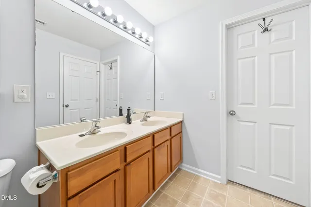 a bathroom with a double vanity sink mirror and