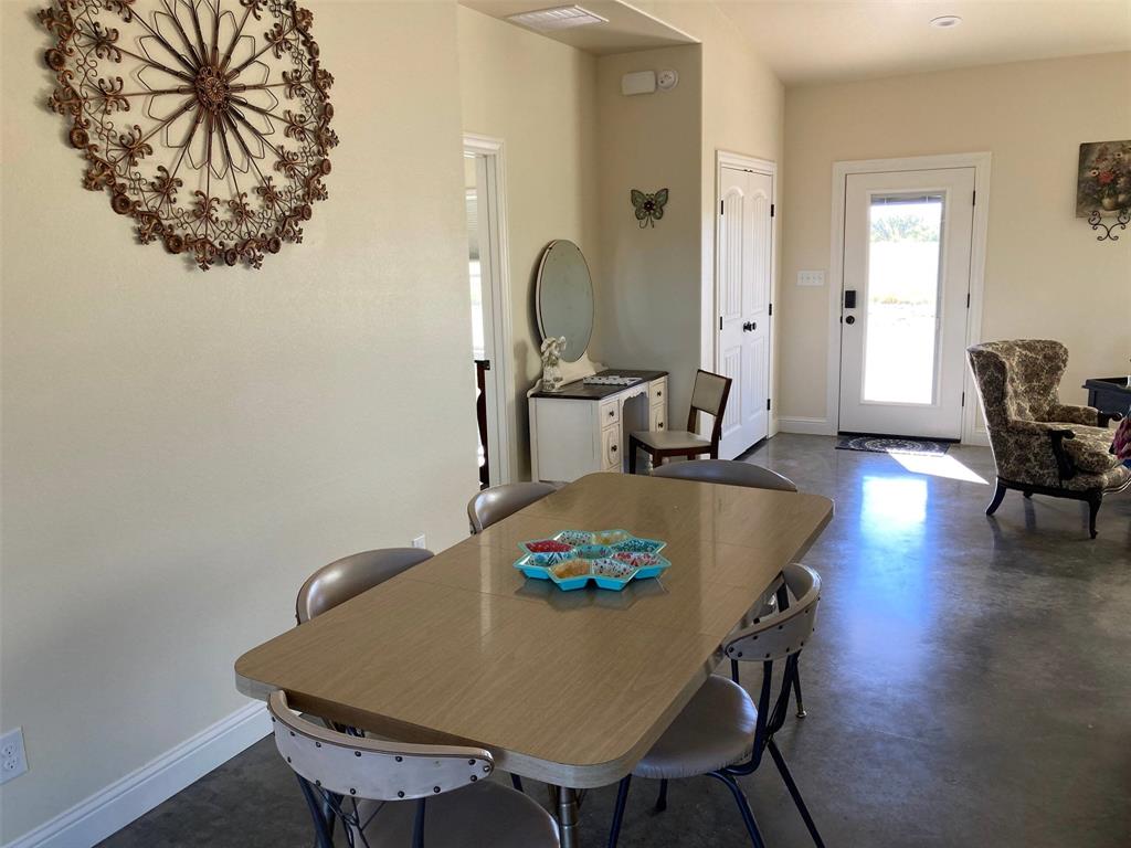 7565 Fm 3116 Anson, TX 79501 - Photo 6 of 15 Light-filled entryway featuring a glass-paneled entry door, a white six-panel interior door, and concrete flooring
