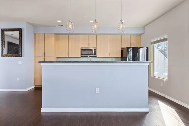 a kitchen with stainless steel appliances granite countertop a sink a stove and a microwave