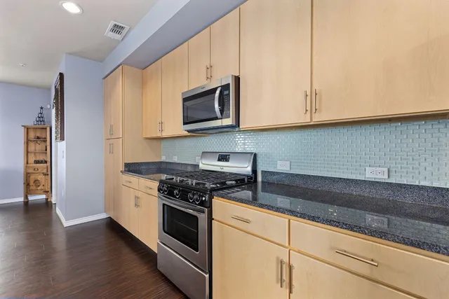 a kitchen with kitchen island stainless steel appliances a sink and a stove