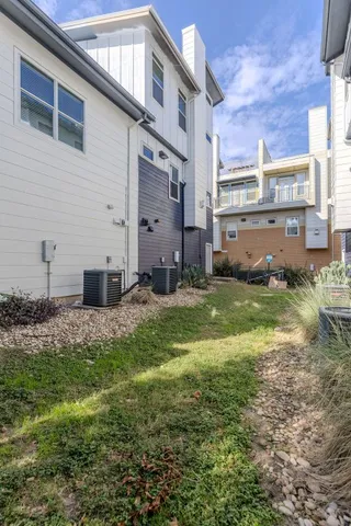 a view of a white house with large windows and a small yard