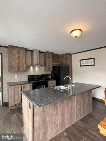 a kitchen with kitchen island granite countertop a sink and a stove
