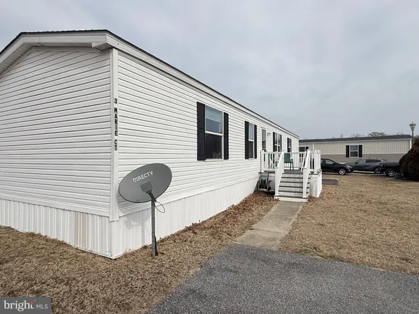 a view of a house with a patio and a yard