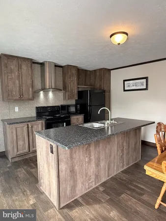 a kitchen with kitchen island granite countertop a stove and a sink