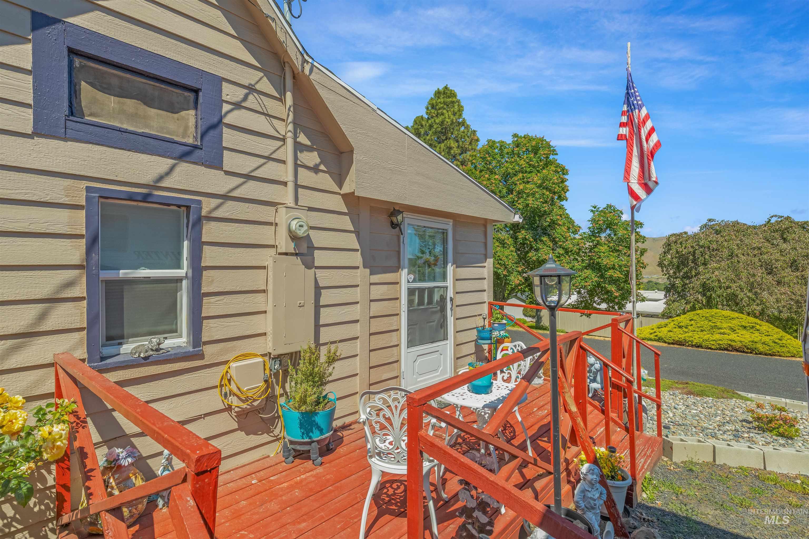 238 Hillcrest Road Lewiston, ID 83501 - Photo 5 of 27 Exterior siding featuring a multi-level red-stained deck with a decorative post lamp