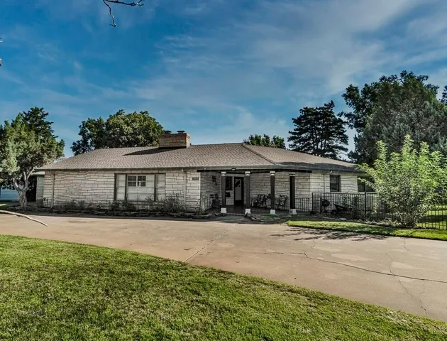 a view of a house with a yard and potted plants