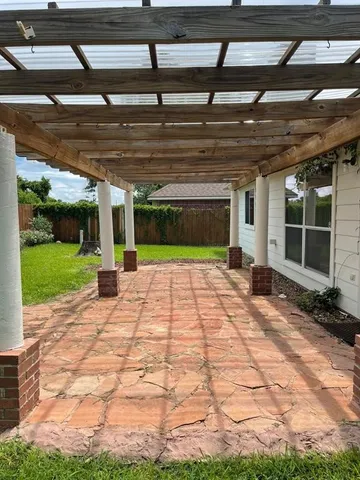 a view of a big yard with plants and large trees