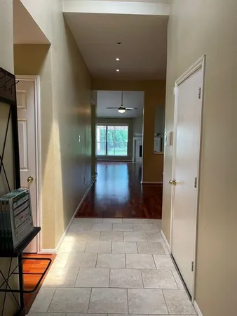 a view of a room with wooden floor a ceiling fan and staircase