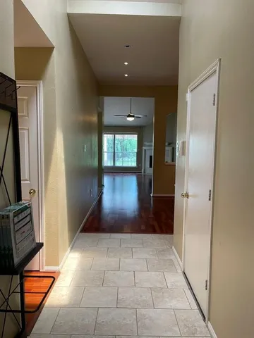 a view of a room with wooden floor a ceiling fan and staircase