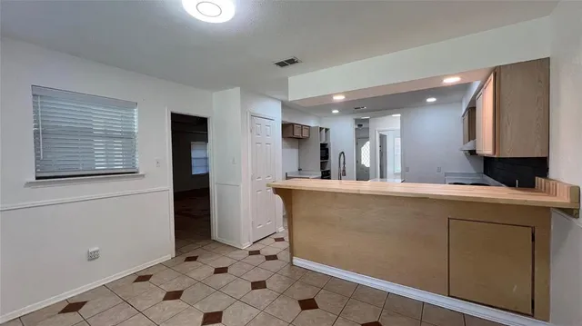 a view of kitchen with stainless steel appliances granite countertop cabinets and window