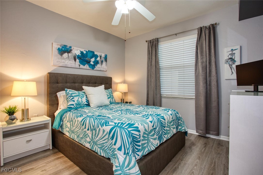 10371 Butterfly Palm Drive, Unit 834 Fort Myers, FL 33966 - Photo 14 of 22 a bedroom with a bed and a flat screen tv