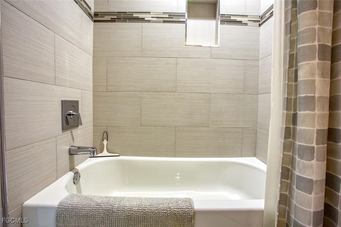 10371 Butterfly Palm Drive, Unit 834 Fort Myers, FL 33966 - Photo 17 of 22 a bathroom with a bathtub and shower