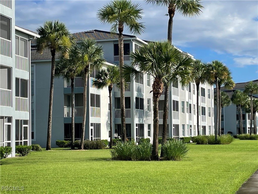 10371 Butterfly Palm Drive, Unit 834 Fort Myers, FL 33966 - Photo 21 of 22 a front view of multi story residential apartment building with yard and green space