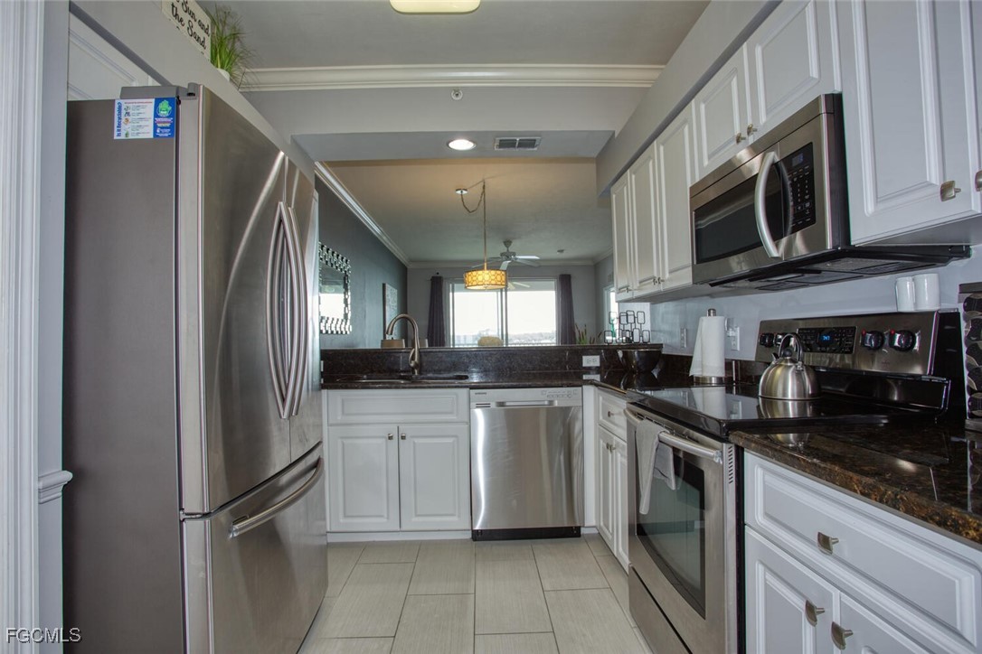 10371 Butterfly Palm Drive, Unit 834 Fort Myers, FL 33966 - Photo 4 of 22 a kitchen with stainless steel appliances granite countertop a refrigerator and a sink