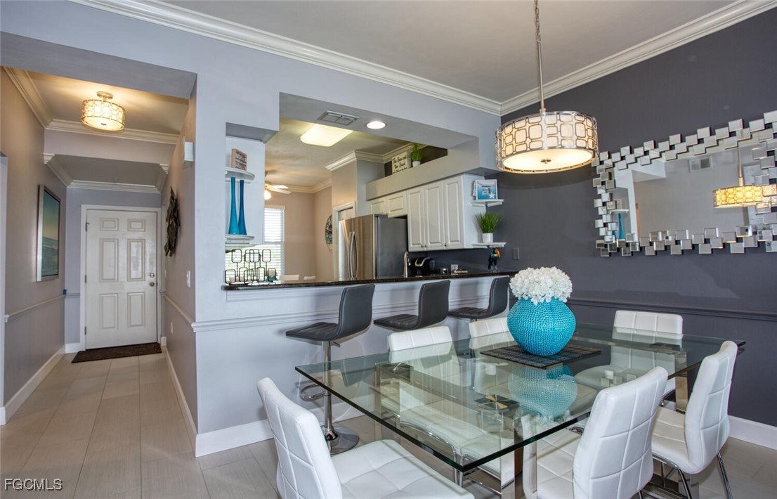 10371 Butterfly Palm Drive, Unit 834 Fort Myers, FL 33966 - Photo 7 of 22 a dining room with wooden floor a chandelier a wooden table and chairs