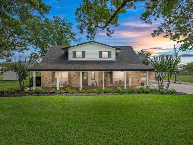 a front view of a house with a yard and trees