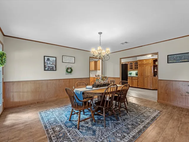 a view of a dining room with furniture and chandelier