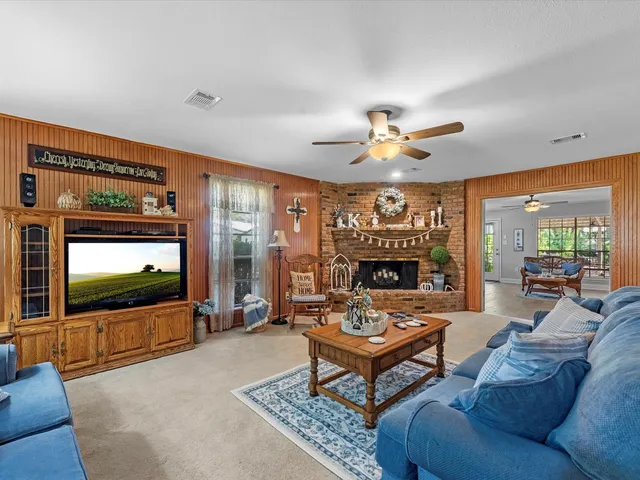 a living room with furniture a fireplace and a flat screen tv