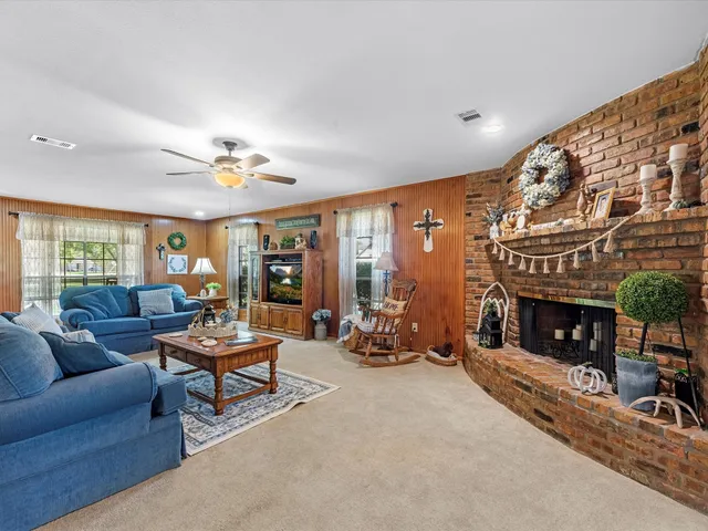 a living room with furniture a fireplace and a floor to ceiling window