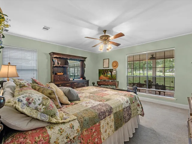a bedroom with a large bed and a chandelier