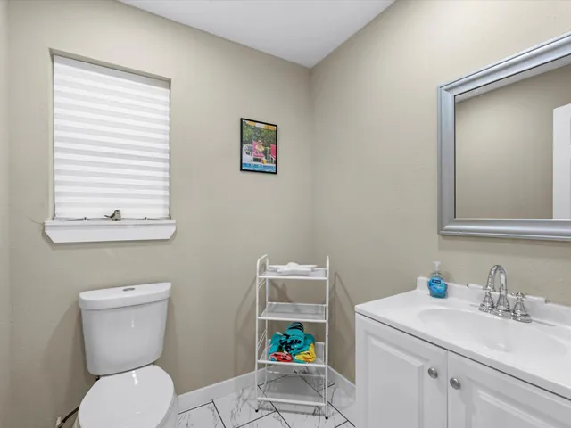 a bathroom with a toilet a sink and a mirror