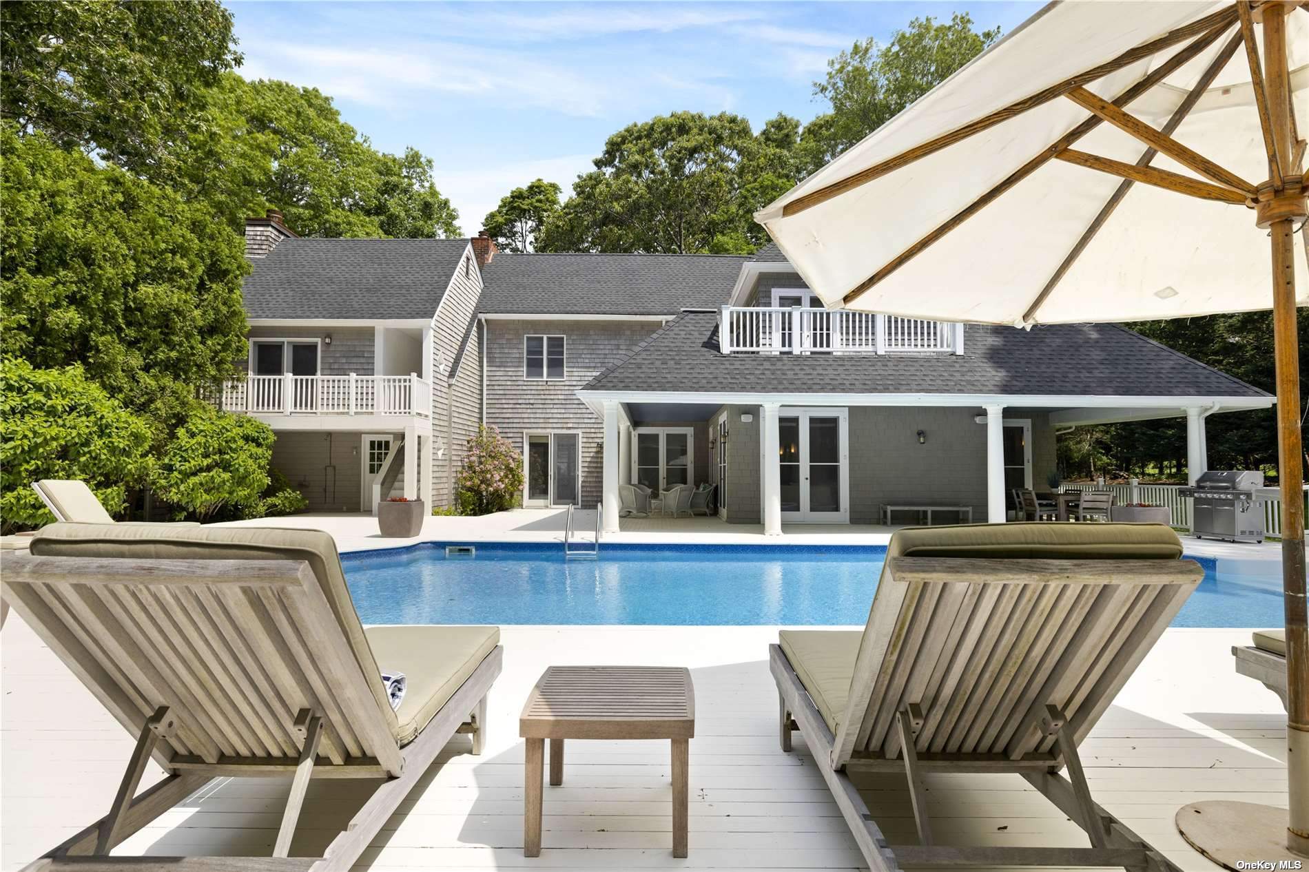 a view of a house with pool and chairs