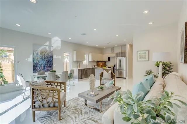 a living room with kitchen island furniture and a view of kitchen appliances