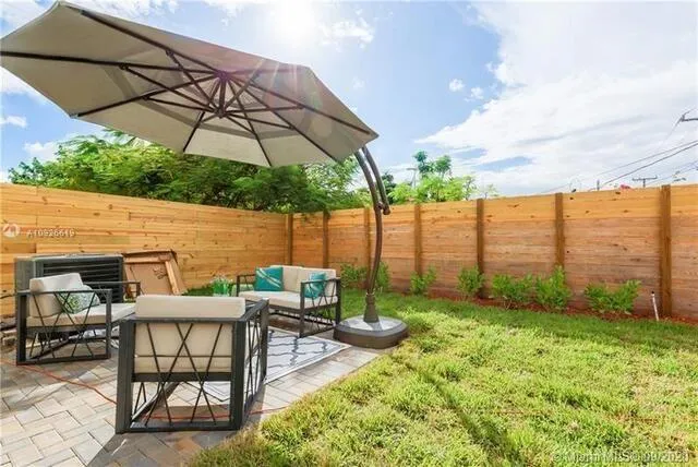 a view of yard with furniture and umbrella