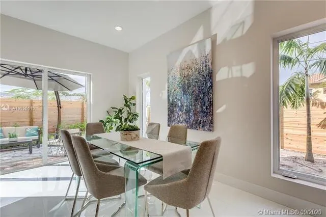 a dining room with furniture and large windows