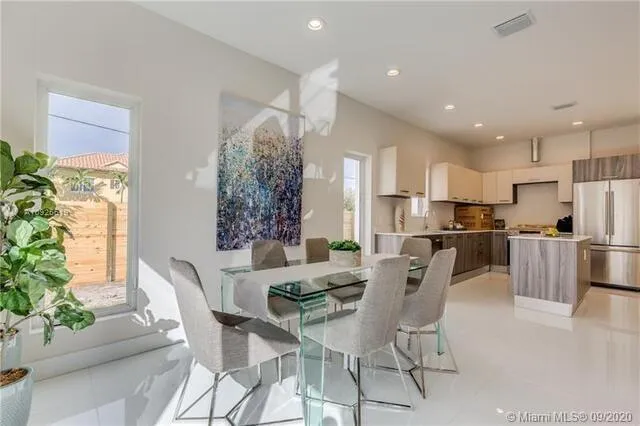 a view of a dining room with furniture and a kitchen