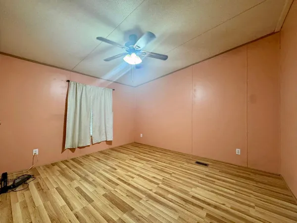 a view of a room with a ceiling fan and wooden floor