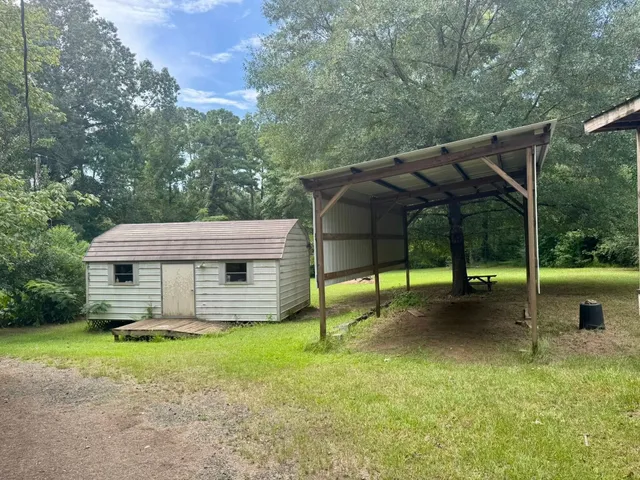 a view of a house with backyard and sitting area