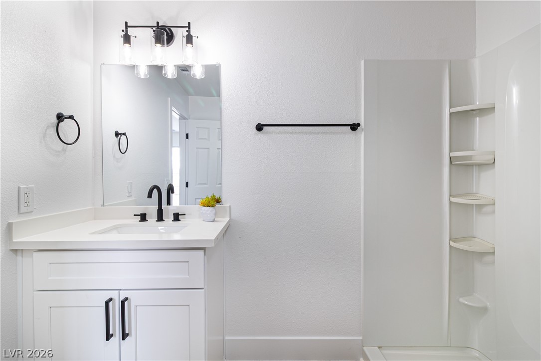 1891 Brian Road Pahrump, NV 89048 - Photo 32 of 50 Bathroom featuring vanity, a shower, and a textured wall