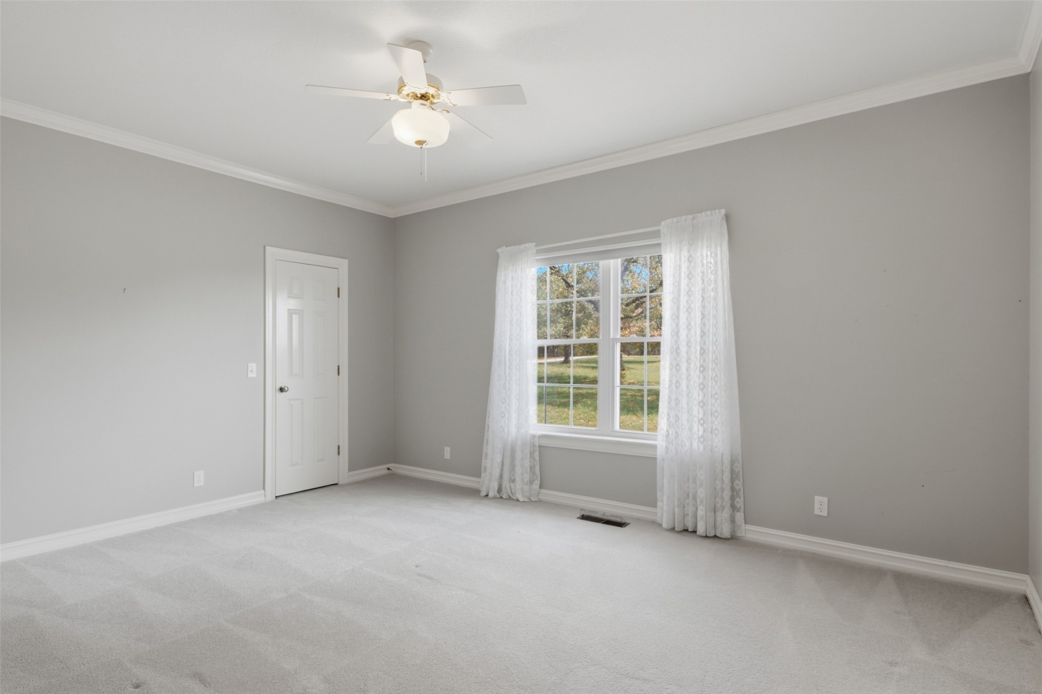 17875 East 589 Road Inola, OK 74036 - Photo 25 of 73 Bright room featuring a ceiling fan with light fixture, double-hung windows, crown molding, and neutral-toned carpeting, walk in closet and Jack and Jill bathroom