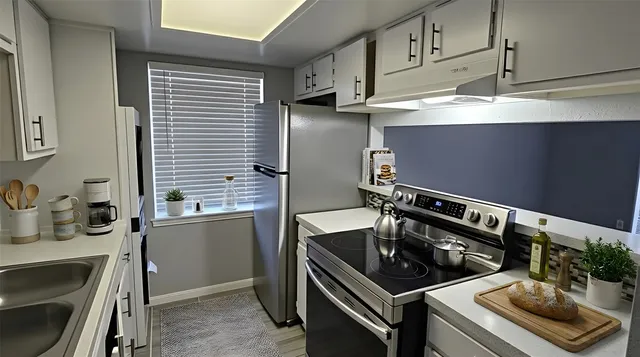 a kitchen with appliances cabinets and a window
