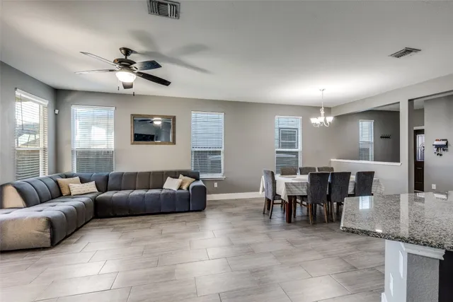 a living room with furniture a dining table and chandelier