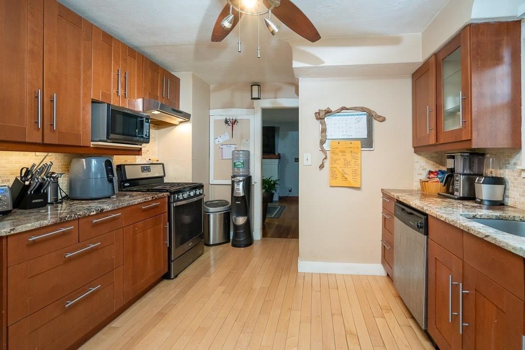 19 Perkins Street Springfield, MA 01118 - Photo 8 of 29 a kitchen with stainless steel appliances granite countertop wooden cabinets a refrigerator a stove a sink and a wooden floors