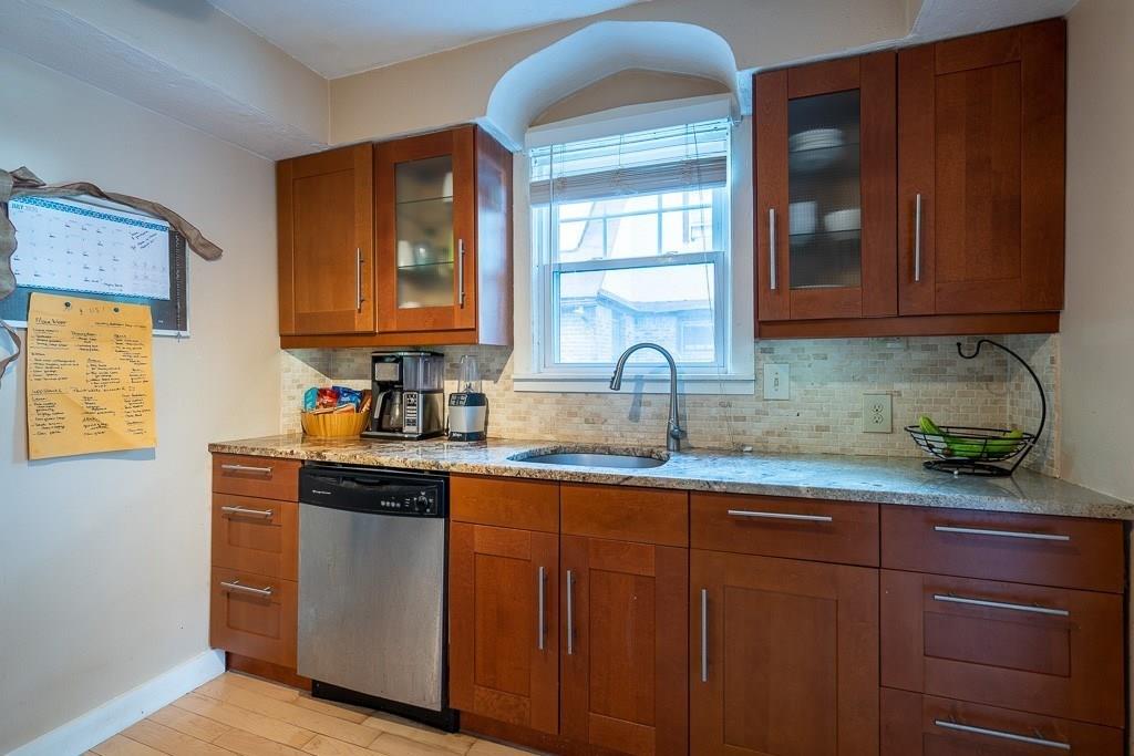 19 Perkins Street Springfield, MA 01118 - Photo 9 of 29 a kitchen with stainless steel appliances granite countertop wooden cabinets a sink and dishwasher with wooden floor