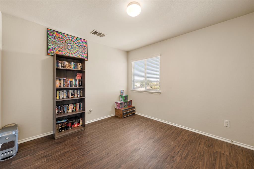 6544 Mundo Drive Waco, TX 76712 - Photo 11 of 21 a room with wooden floor and book shelf