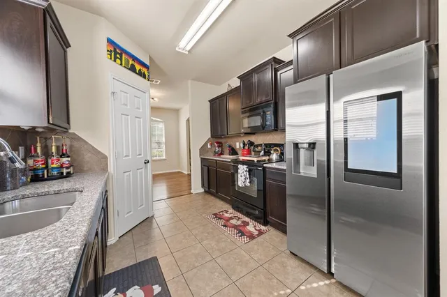 a kitchen with granite countertop a refrigerator and a sink