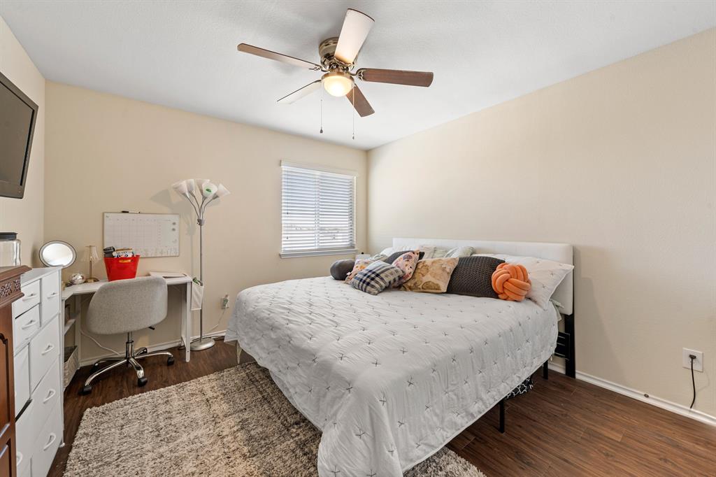 6544 Mundo Drive Waco, TX 76712 - Photo 10 of 21 a bedroom with a bed a desk and chair with wooden floor