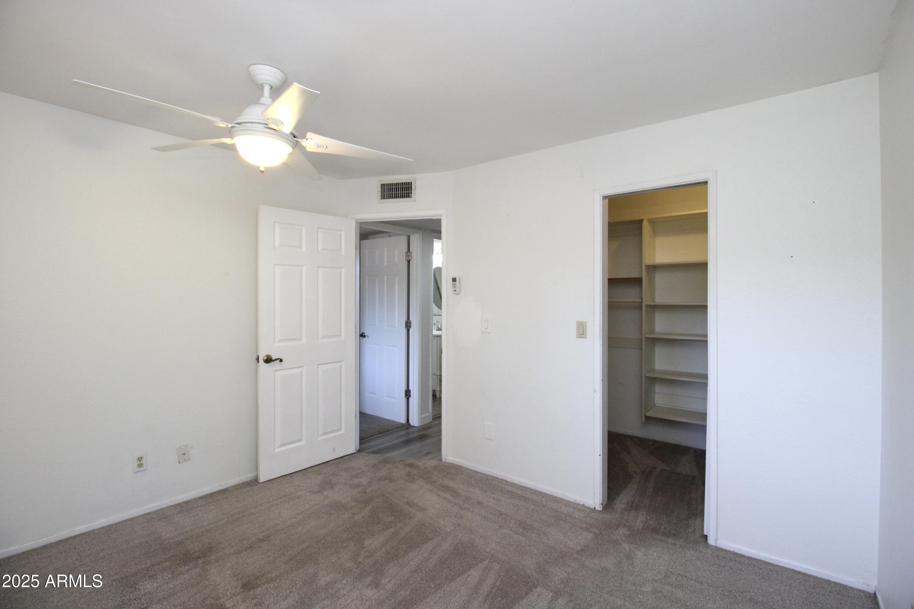 5330 North Central Avenue, Unit 19 Phoenix, AZ 85012 - Photo 17 of 33 an empty room with closet and a chandelier fan